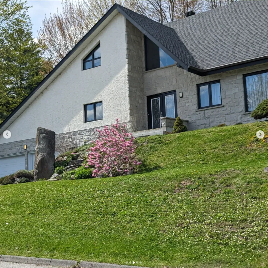APRÈS — même propriété après l'intervention d'Eco Pelouse Estrie : pelouse verte et soignée en lignes