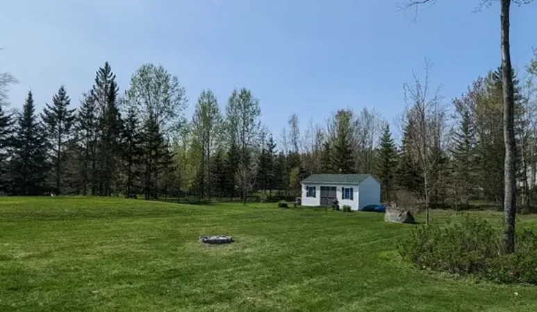 Grand terrain dégagé et propre au printemps avec cabanon, nettoyage de terrain en Estrie